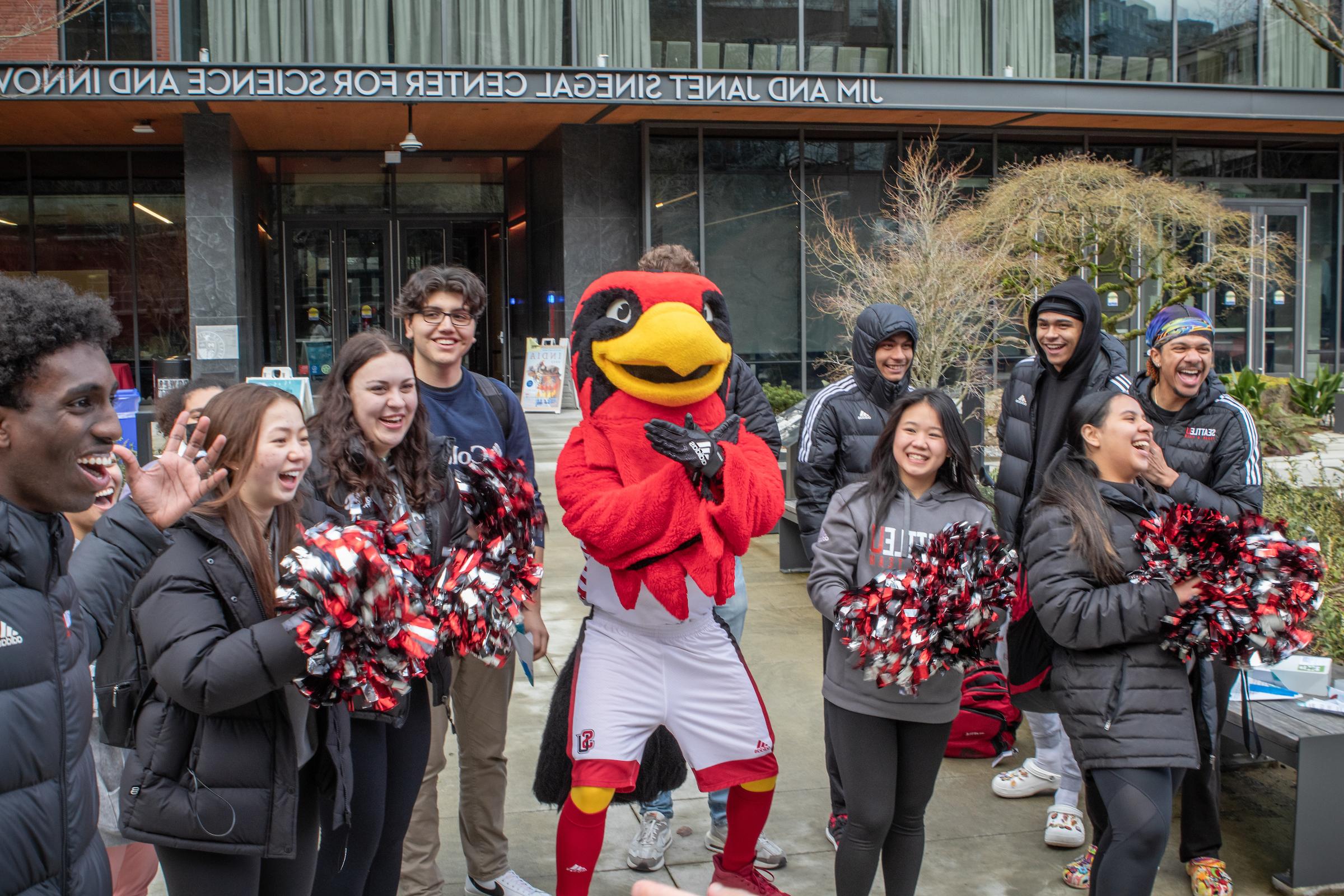 a group of students and Rudy the mascot rallying with pom-poms